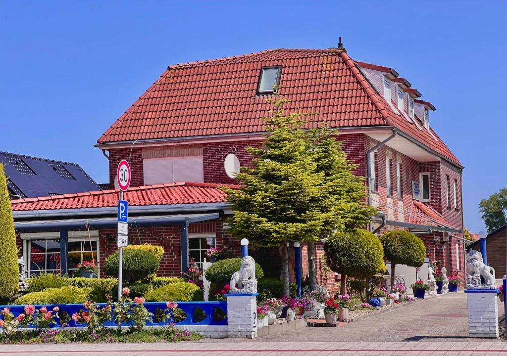a red brick building with a red roof at Pension Dang in Norddeich