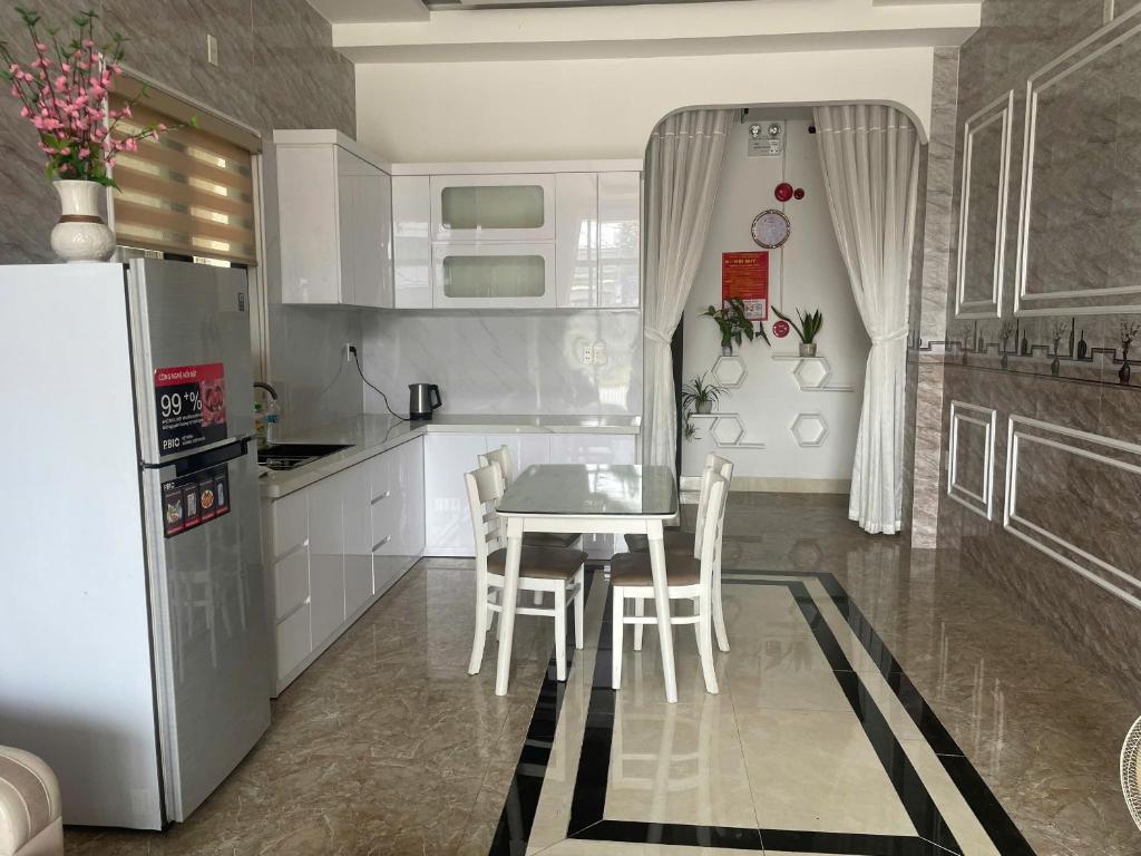 a kitchen with a table and chairs and a refrigerator at Lami House in Danang