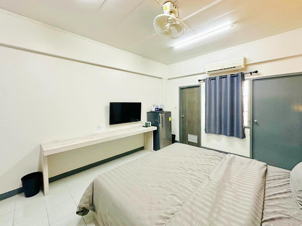 a bedroom with a bed and a flat screen tv at H-Hub BBT in Ban Khlong Yuan