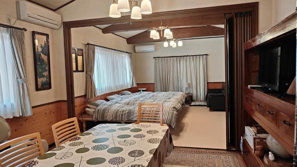 a bedroom with a bed and a table and a television at Minpaku Nambu in Koka