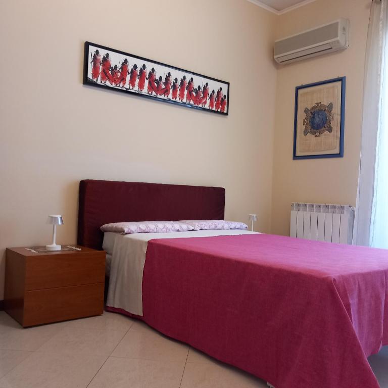 a bedroom with a bed with a purple blanket at New Magnolia House in Belpasso