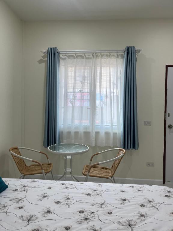 a bedroom with a table and chairs and a window at 529 Cozy rooms in Ban Si Than