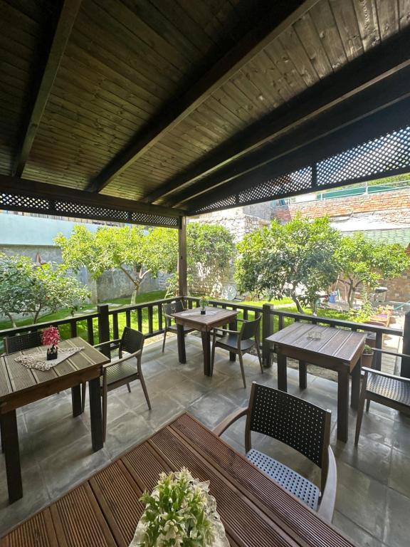 an outdoor patio with tables and chairs and trees at Bujtina Valgent in Berat