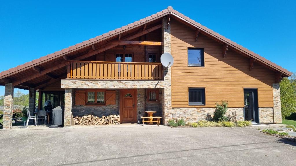 a log cabin with a balcony on top of it at STUDIO indépendant dans un chalet traditionnel in Ban-sur-Meurthe-Clefcy