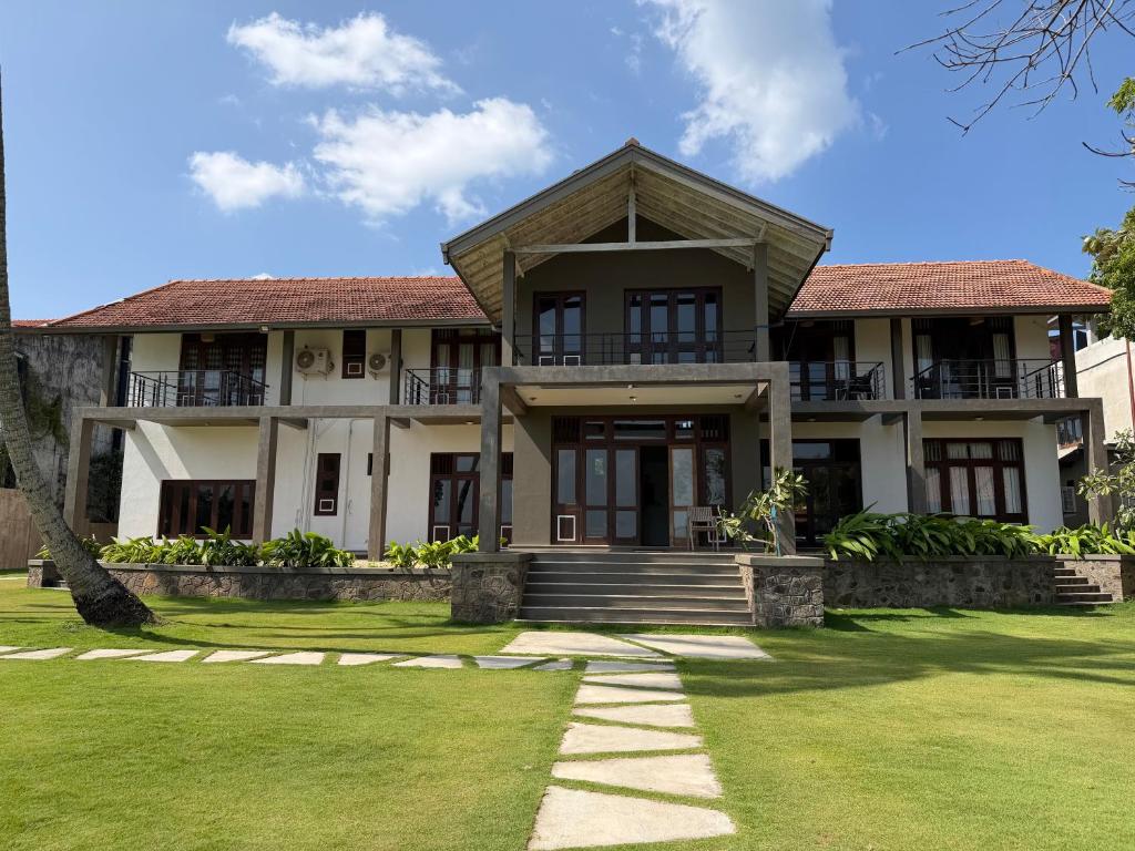 a large house with a green lawn in front of it at Aayu Lagoon in Negombo