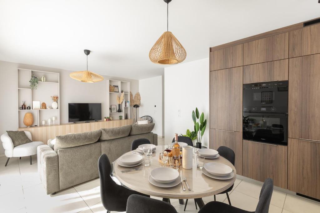 a dining room and living room with a table and chairs at "Lac'Almie" - Appartement 2 chambres avec Terrasse et Parking in Doussard