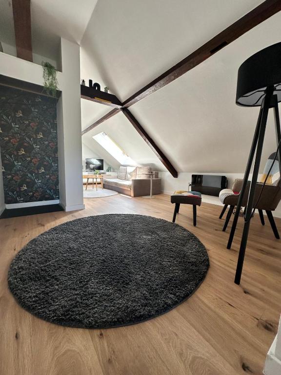 a living room with a black rug on a wooden floor at Haus Lilium-Gemütliche Dachgeschoss Wohnung in Freudenstadt