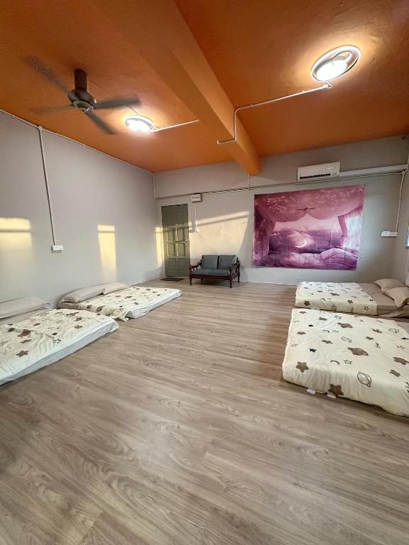 a room with four beds and a couch in it at Baby Devil Studio 8 pax Homestay in Sibu