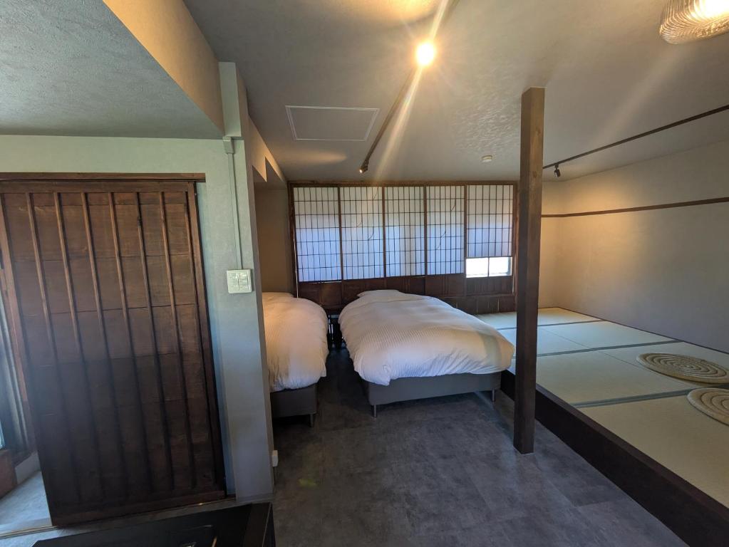 a room with two beds in a room with at 川まで徒歩1分川沿いにある一軒宿あせみ in Nakajima