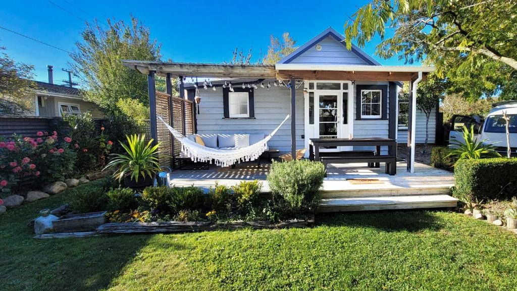 a porch with a hammock and a house at Urban Cottage in Masterton