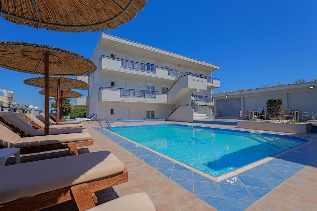 a swimming pool in front of a villa at Sueño beach hotel in Polychrono