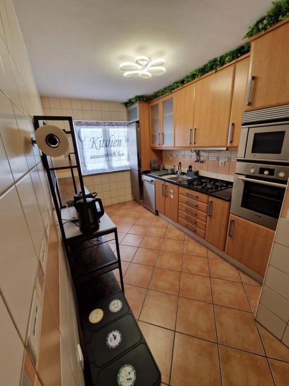 a kitchen with wooden cabinets and a camera on a shelf at Caparica City & Beach in Caparica