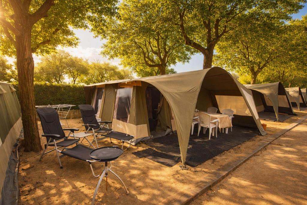 a group of tents and chairs and trees at glamping bravatents in Blanes