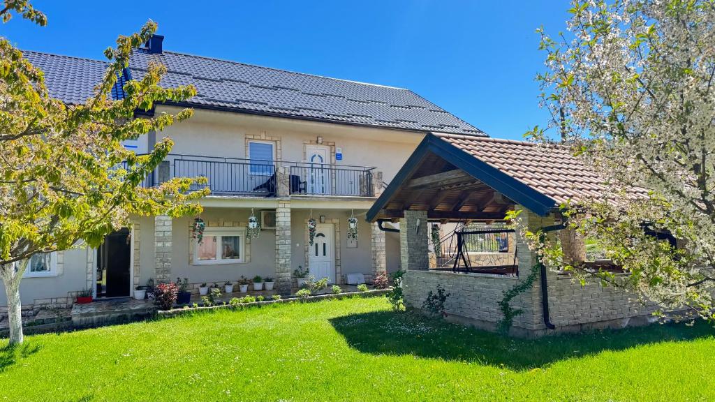 a house with a balcony and a yard at Apartman Šimić in Gračac