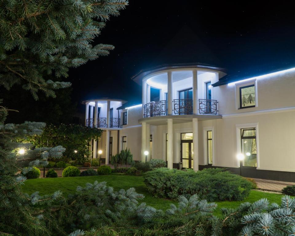 a large white house at night at Galaktyka Hotel in Stantsiya Biskovitse