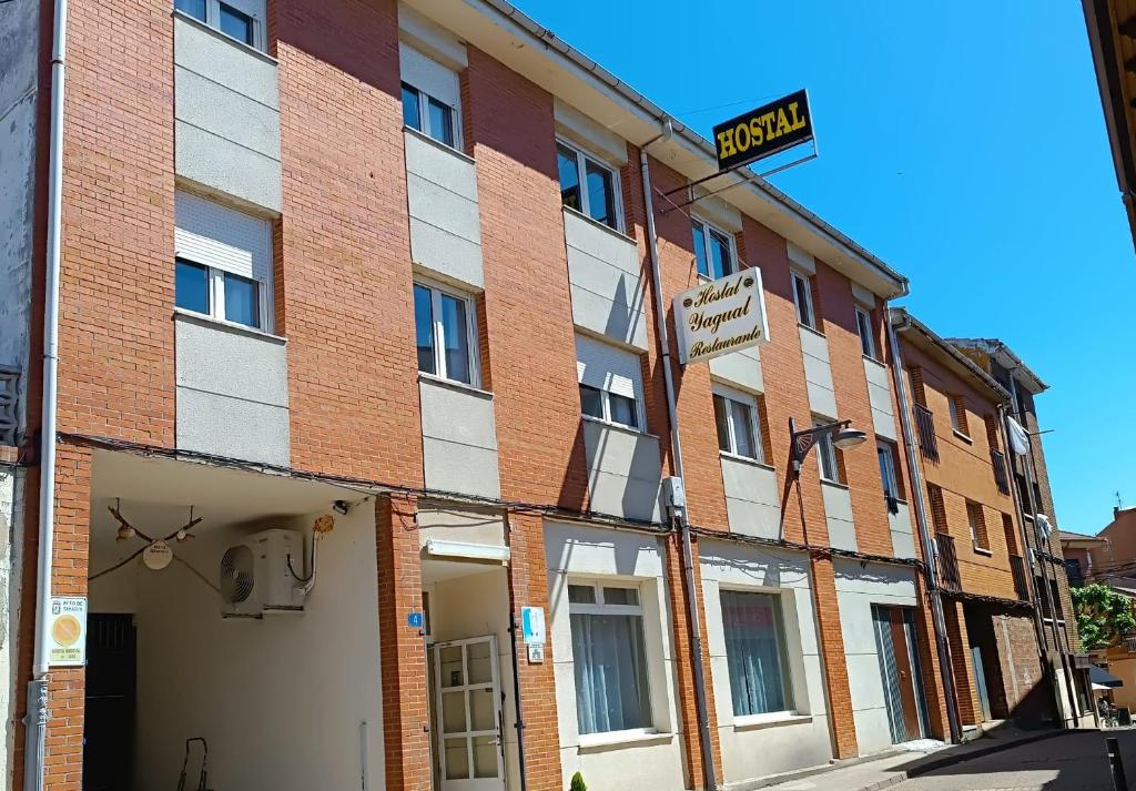 a brick building with a street sign in front of it at Hostal Restaurante Yagual in Sahagún