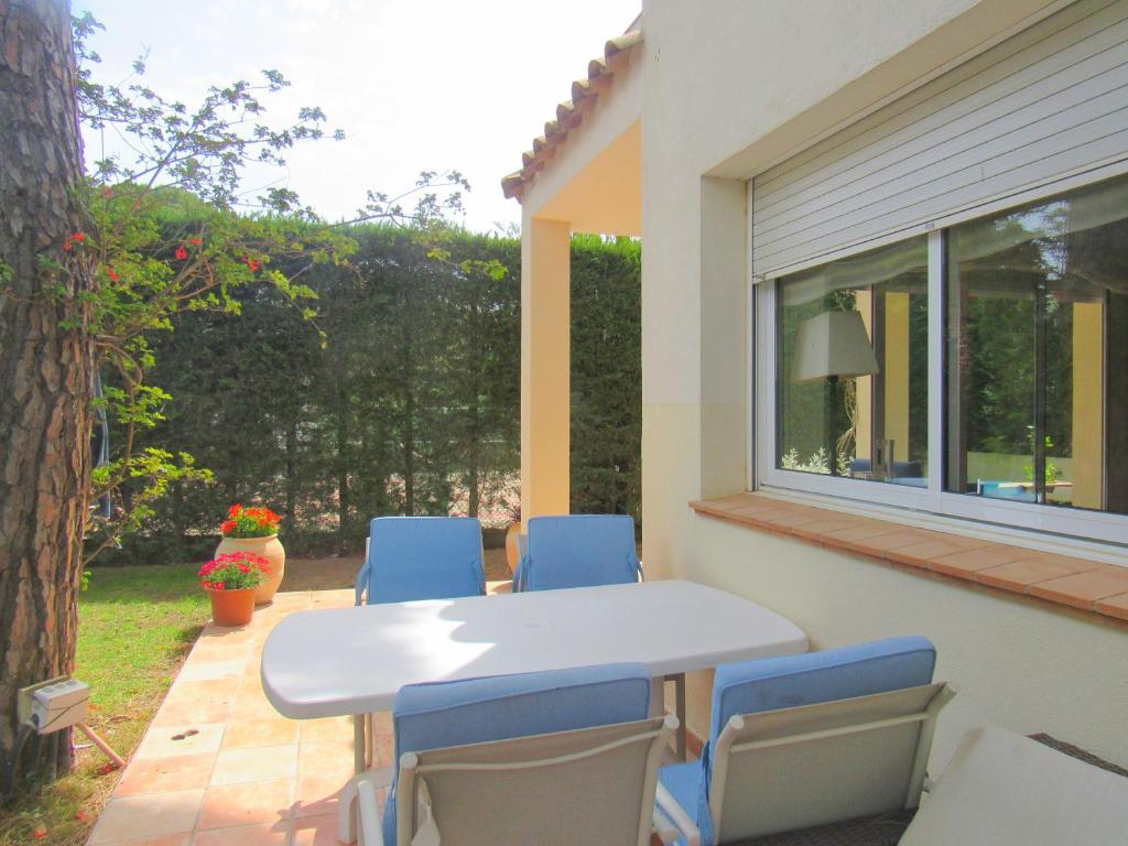 a table and chairs on a patio with a window at Casa adosada en Calella de Palafrugell in Palafrugell
