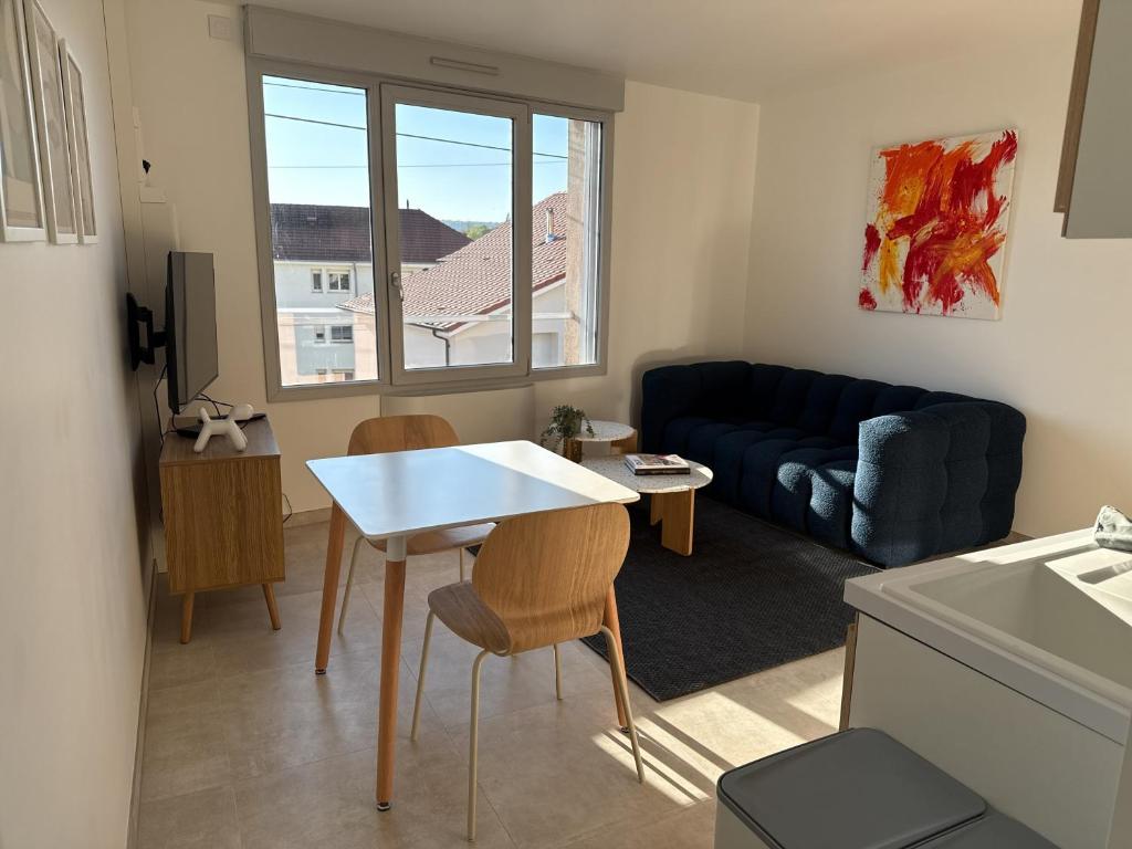 a living room with a table and a couch at La Bergerie 2 in Neufchâteau