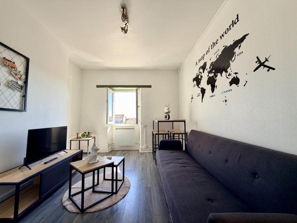 a living room with a couch and a tv at Appartement VAIS in Cognac