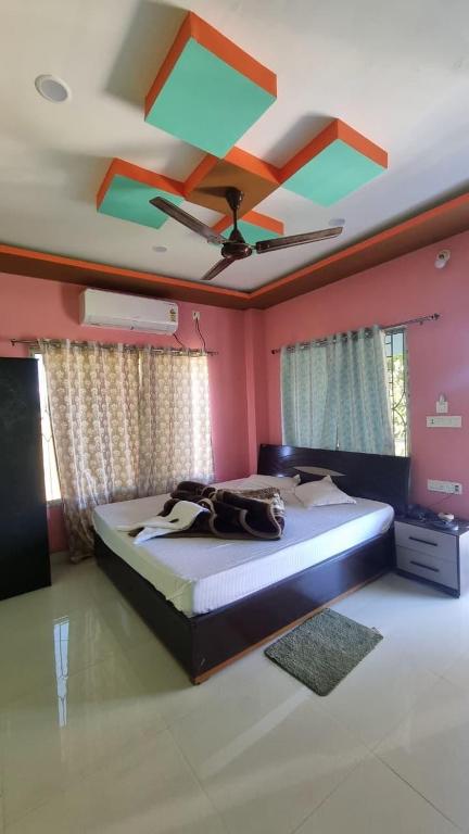 a bedroom with a large bed with a ceiling at North Queen Resort in Mal bazar