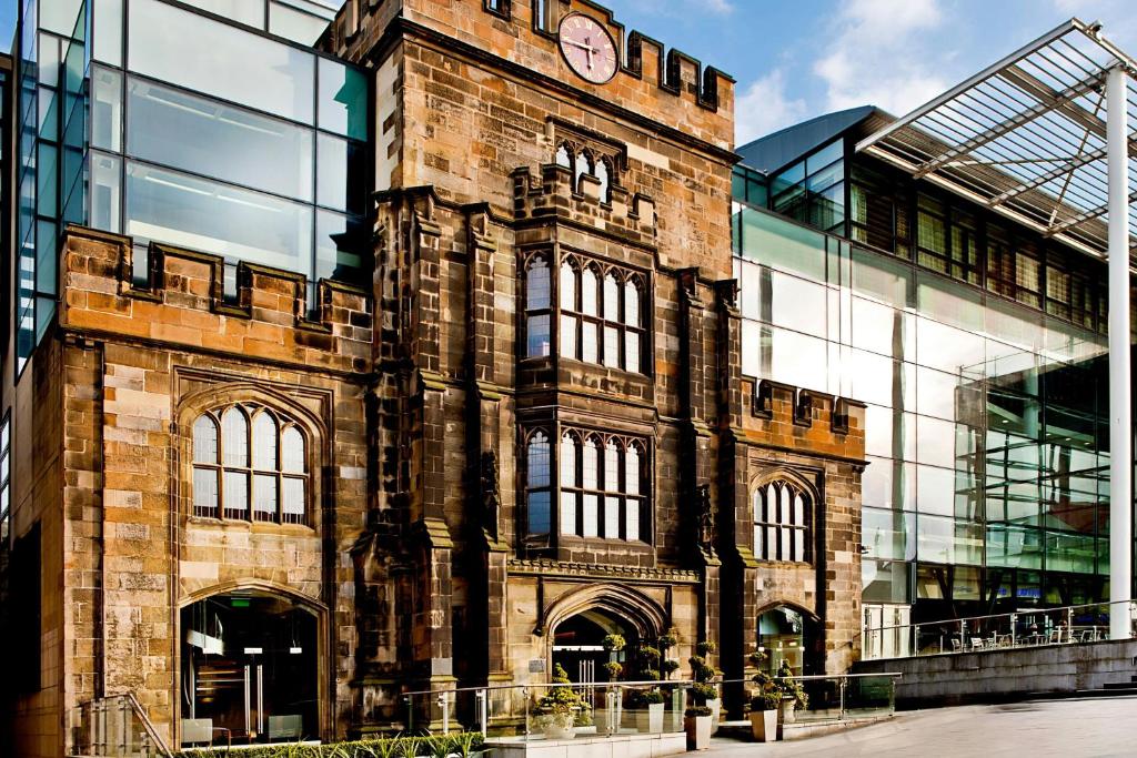 a large brick building with a clock on it at The Glasshouse, Autograph Collection in Edinburgh