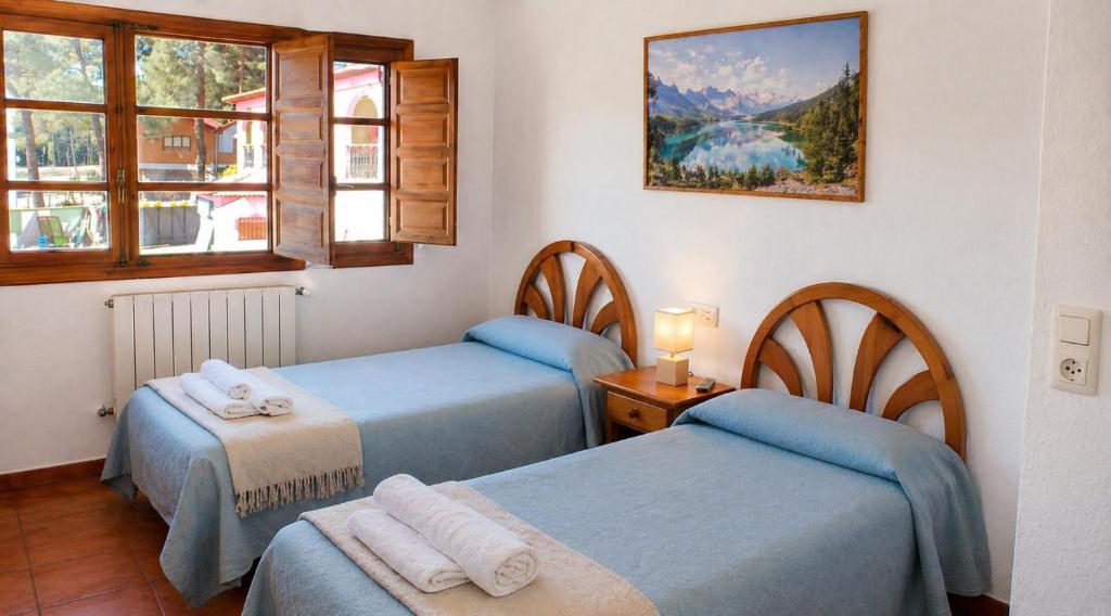 a room with three beds and a window at Pensión San Cristóbal by Bossh! Hotels in Cuenca