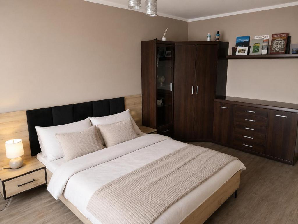 a bedroom with a large bed and a wooden cabinet at Boguszów in Boguszów-Gorce