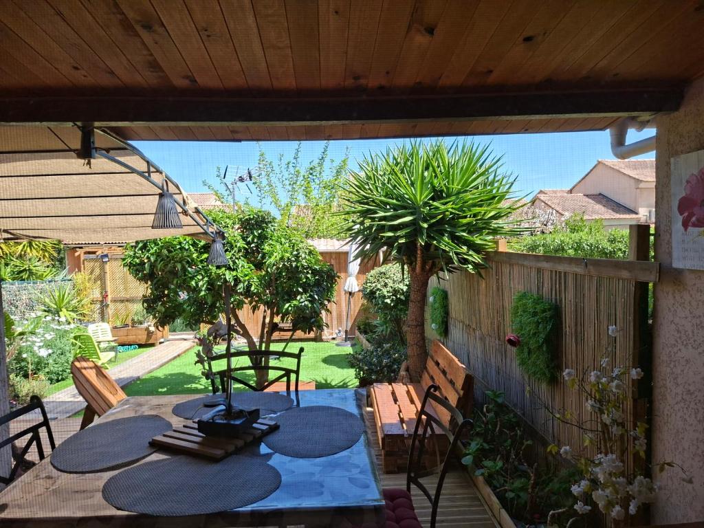 a patio with a table and chairs in a yard at Maison bord de mer a Cervione dans résidence Torra Mare à 20221 Prunete avec piscine collective copropriétaires et matériels de ventilateur dans toutes les pièces in Cervione