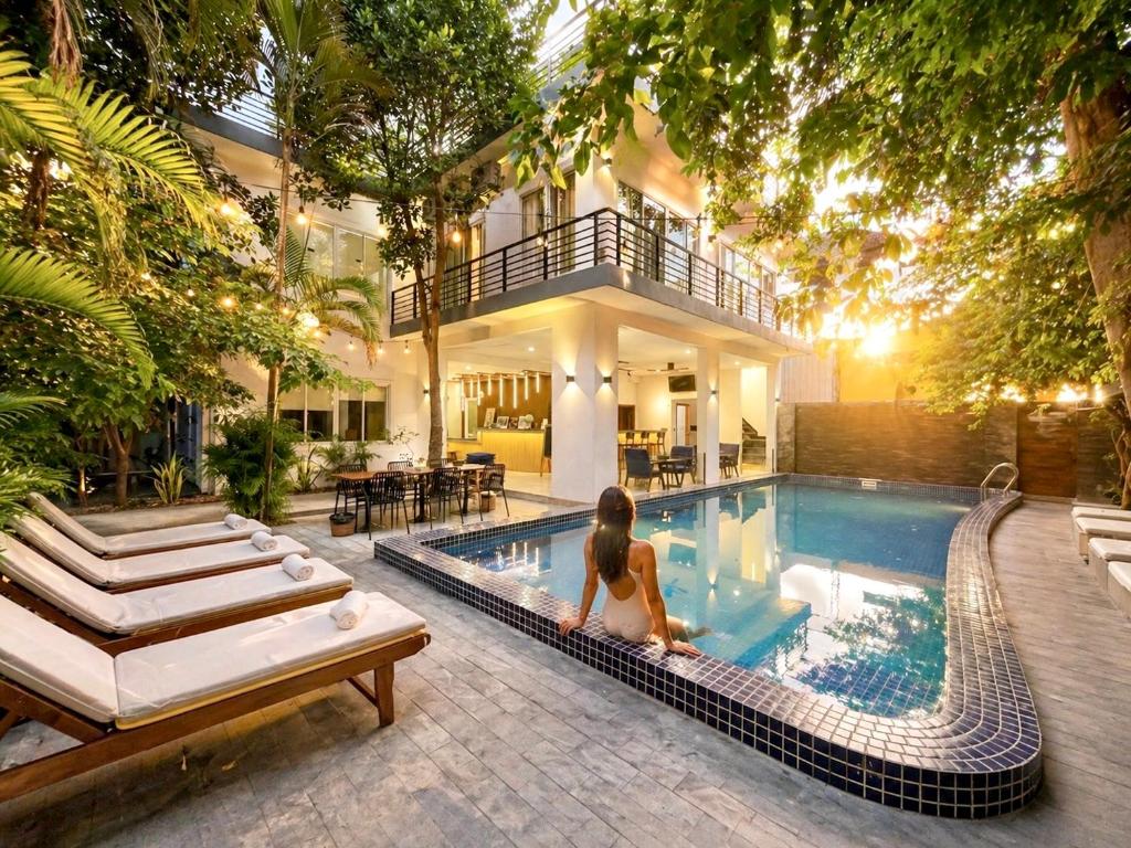 a woman sitting in a swimming pool in a house at SkyVilla BKK - Pool & Chill - Laundry included in Phnom Penh