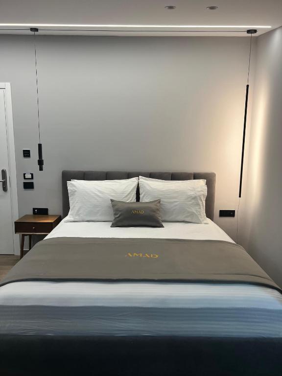 a bedroom with a large bed with white pillows at AMAD Aparthotel in Sarandë