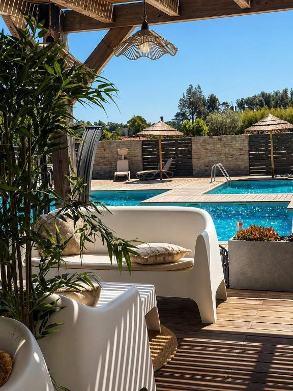 a patio with a white couch and a swimming pool at Cala Serena Saint Cyprien in Lecci