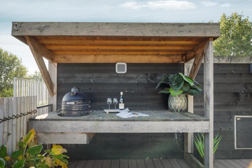 a pergola on a deck with a table and wine glasses at Bed zonder Breakfast in Amsterdam