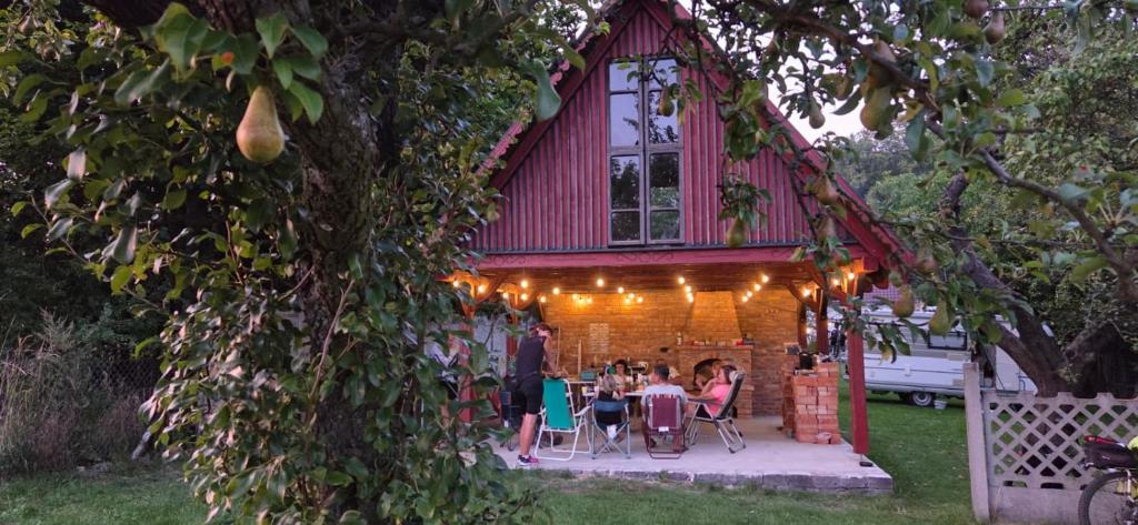 a group of people sitting at tables in front of a house at Folwark Pod Bukowcem in Podzamcze