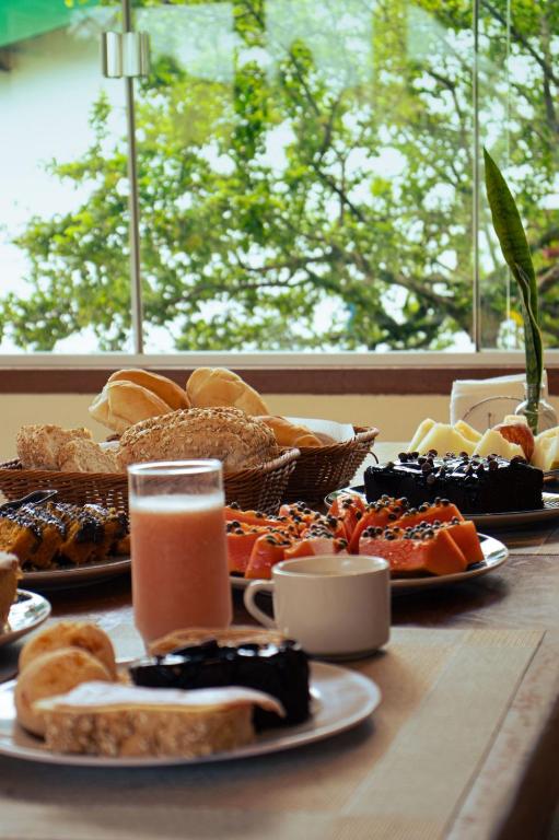 a table with plates of food and glasses of orange juice at POUSADA ACONCHEGO CHAPADA in Alto Paraíso de Goiás