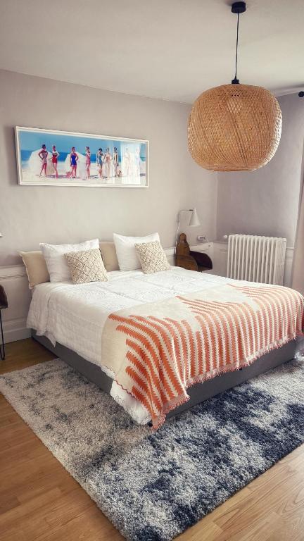 a bedroom with a bed with an orange and white blanket at Maison d'hôte Les Allois in Limoges