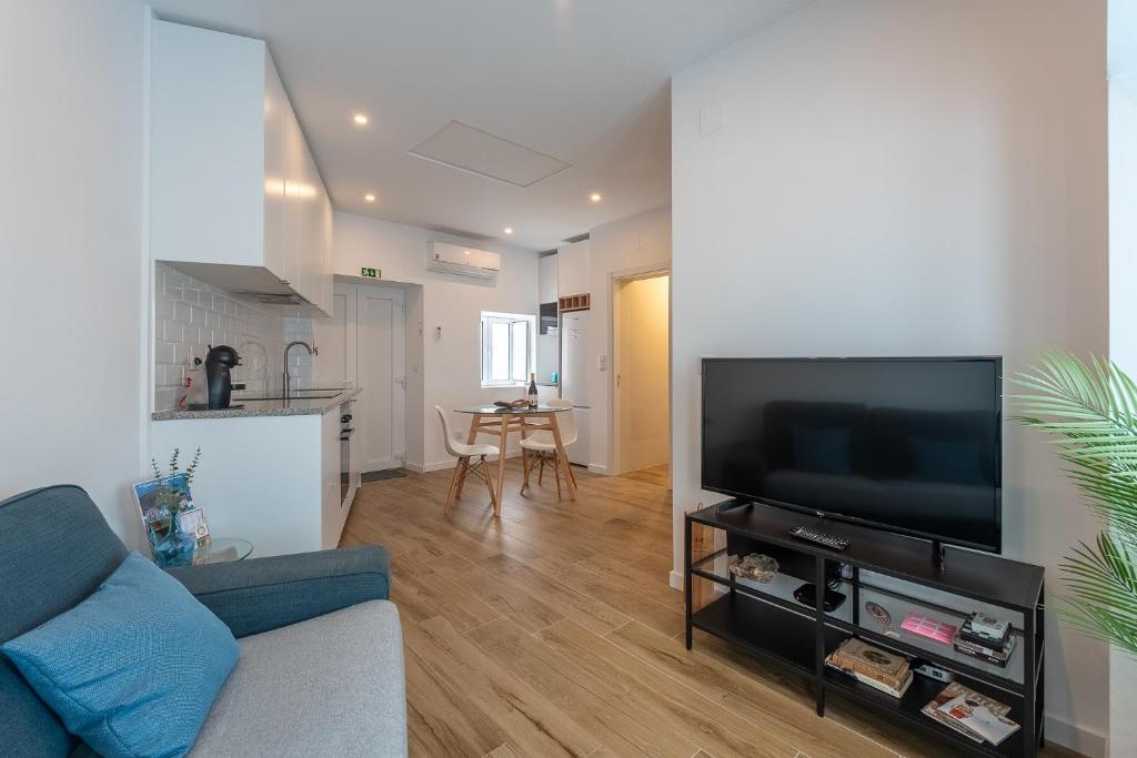 a living room with a couch and a flat screen tv at Cozy Oeiras Home for Beach, Lisbon & Cascais in Paço de Arcos