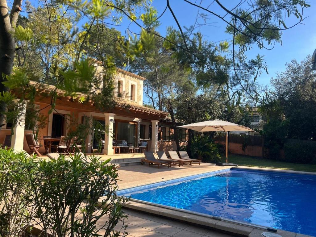 a house with a swimming pool in front of a house at Nispero in Sa Pobla