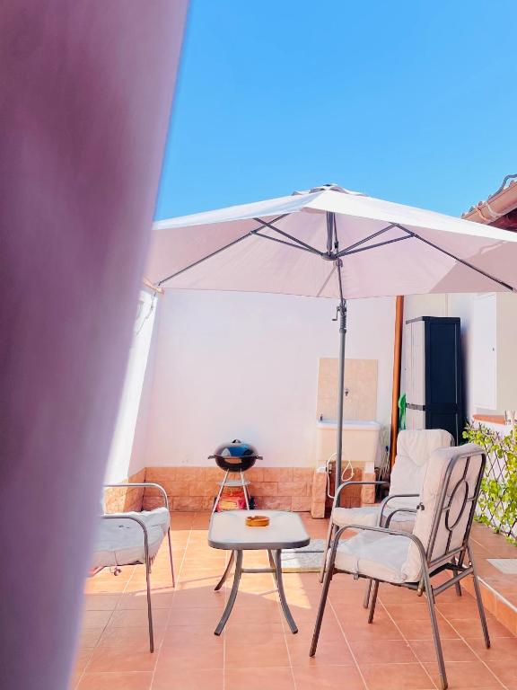 a patio with a table and chairs and an umbrella at DomuMnG in Elmas