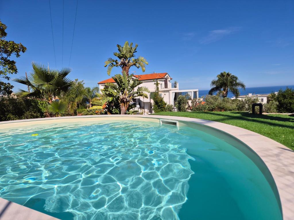 a swimming pool in front of a house at Oasis Villa - Sea View Pool, Sanremo in Sanremo
