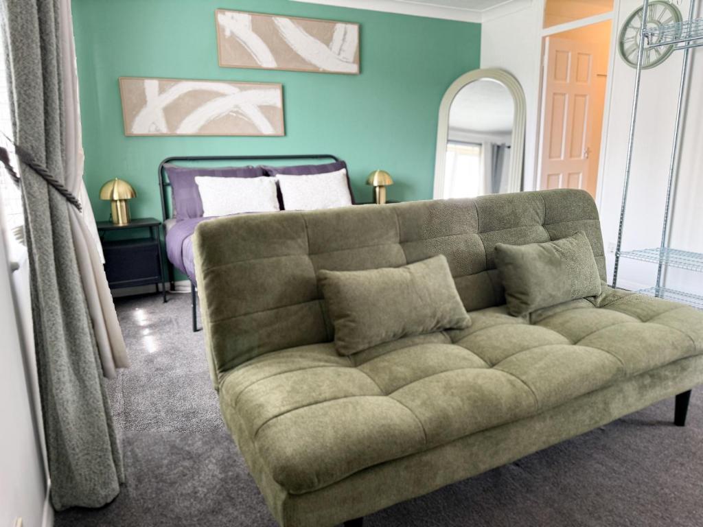 a living room with a couch and a bed at Princess House in Redhill