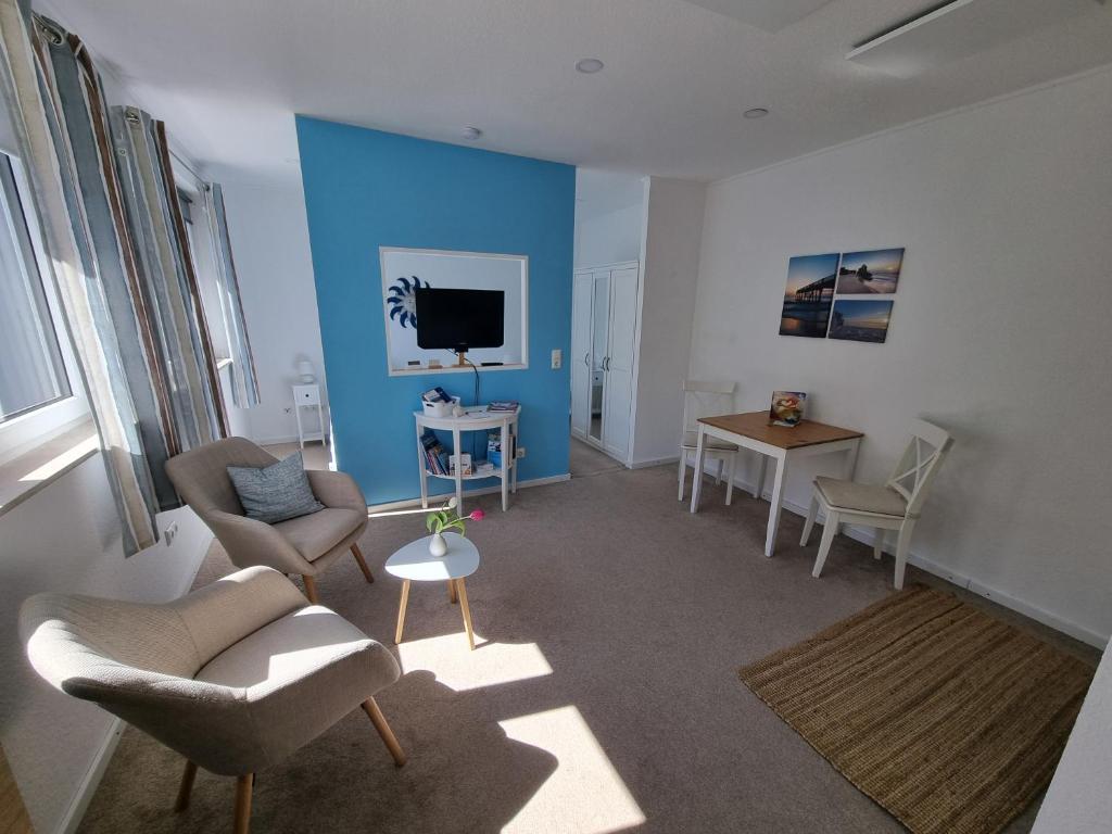 a living room with two chairs and a tv at Auszeit am Rosengarten, Zentrumsnah in Güstrow