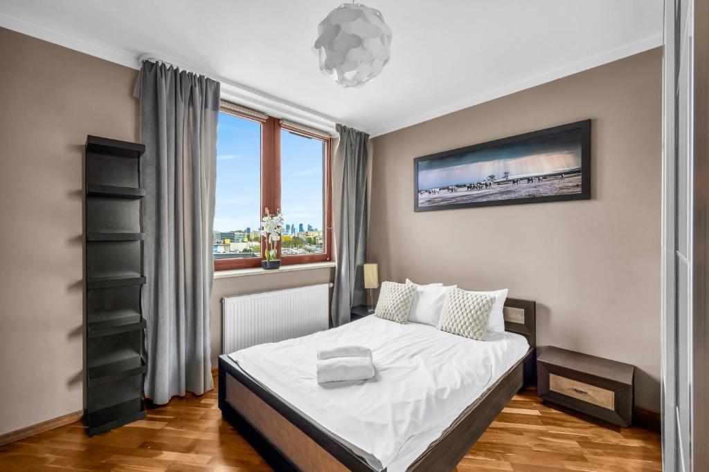 a bedroom with a bed and a window at Spacious 3Rooms Apt with Balcony Parking in Warsaw