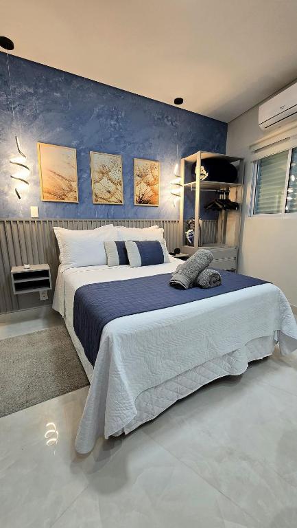 a bedroom with a large bed with a blue wall at Residencial Felicita in Barueri