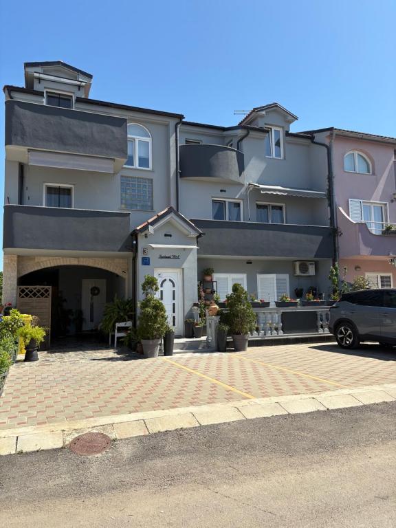 a building with a car parked in front of it at Apartmani M&L in Medulin