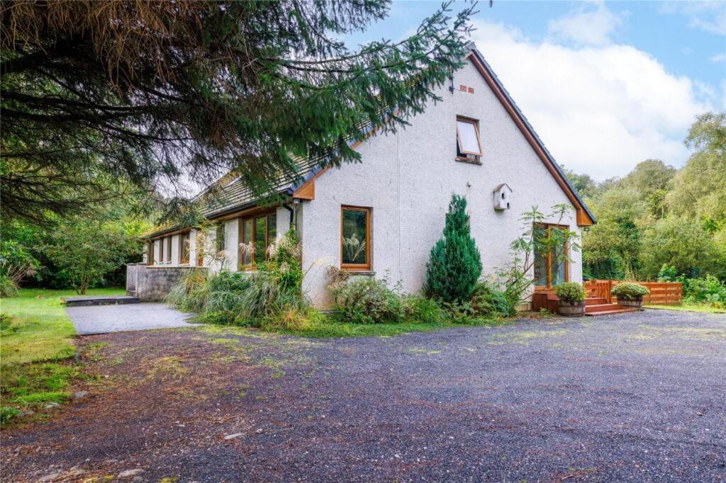 a white house with a gambrel roof at Bluebell Cottage in Tarbert