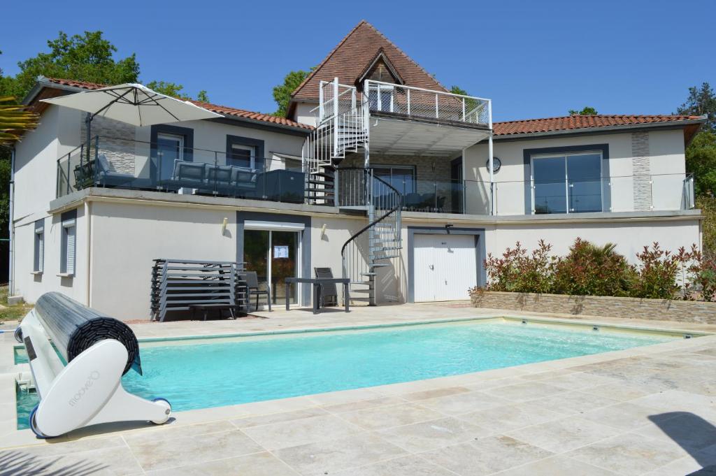 a house with a swimming pool in front of a house at La Tourelle du Lot in Cajarc