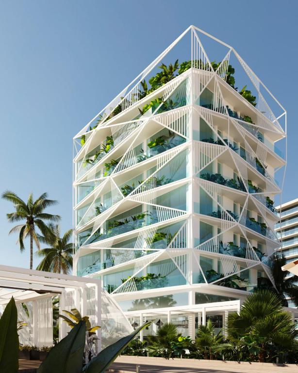 a tall white building with palm trees in front of it at Nava Star Hotel in Durrës