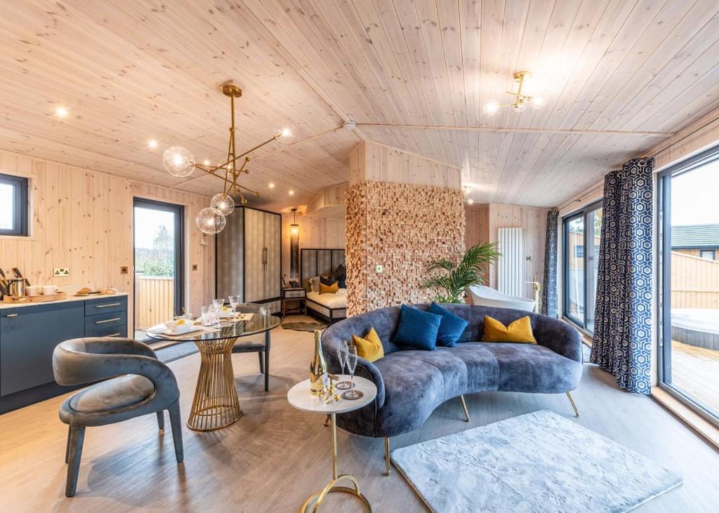 a living room with a blue couch and a table at Ashlea Pools Lodges in Hoptonheath
