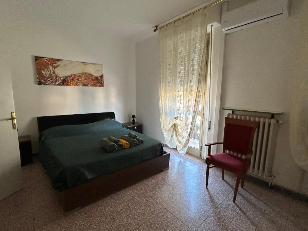a bedroom with a bed and a chair and a window at Affittacamere VITRUVIO in Fano