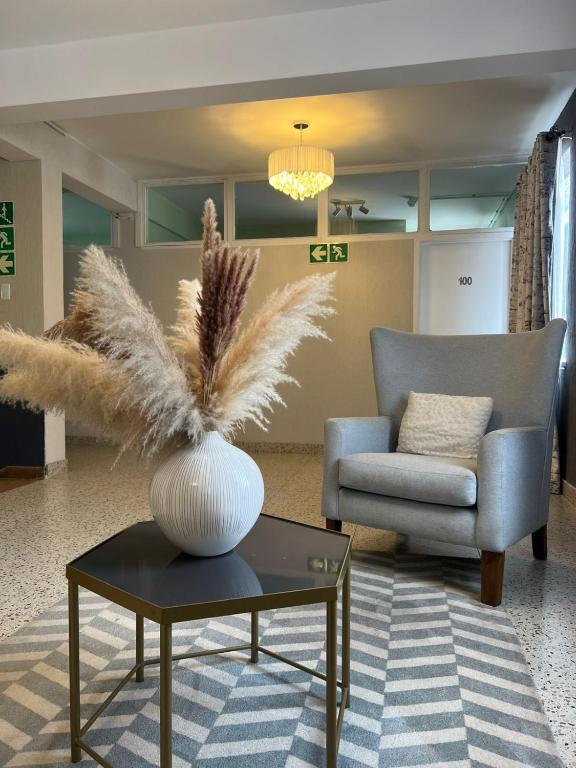 a living room with a couch and a vase on a table at 112 On Park Drive in Gqeberha